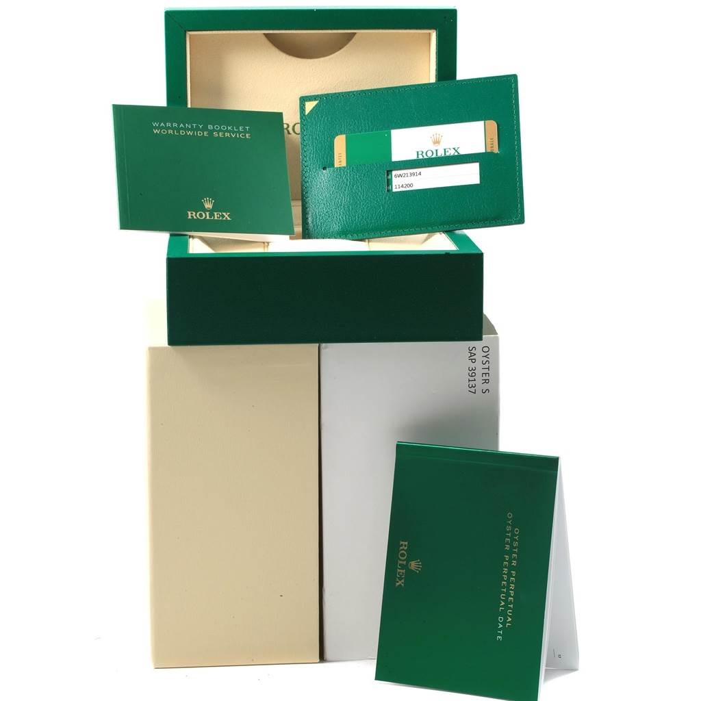 The image shows Rolex Oyster Perpetual 114200 Men
s Stainless Steel Burgundy Dial 114200 Men
s Stainless Steel Burgundy Dial packaging, including a box, warranty booklet, and Best Quality
ity card, viewed from the front.