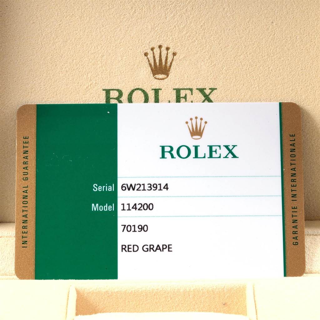 The image shows an international guarantee card for a Rolex Oyster Perpetual 114200 Men
s Stainless Steel Burgundy Dial 114200 Men
s Stainless Steel Burgundy Dial model 114200 with serial number 6W213914.
