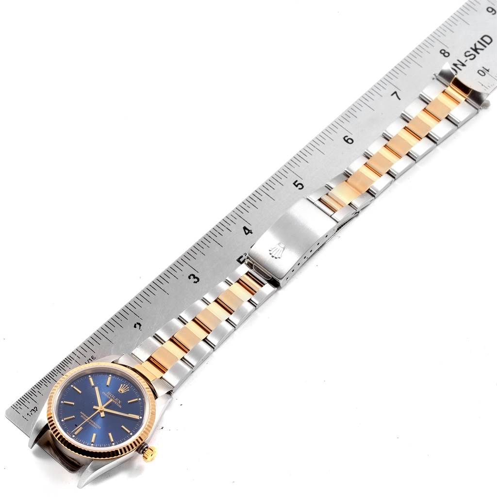 The image shows a top view of a Rolex Oyster Perpetual 14233 Men's Steel and Gold (two tone) Blue Dial 14233 Men's Steel and Gold (two tone) Blue Dial watch, including the face, bracelet, and clasp next to a ruler.