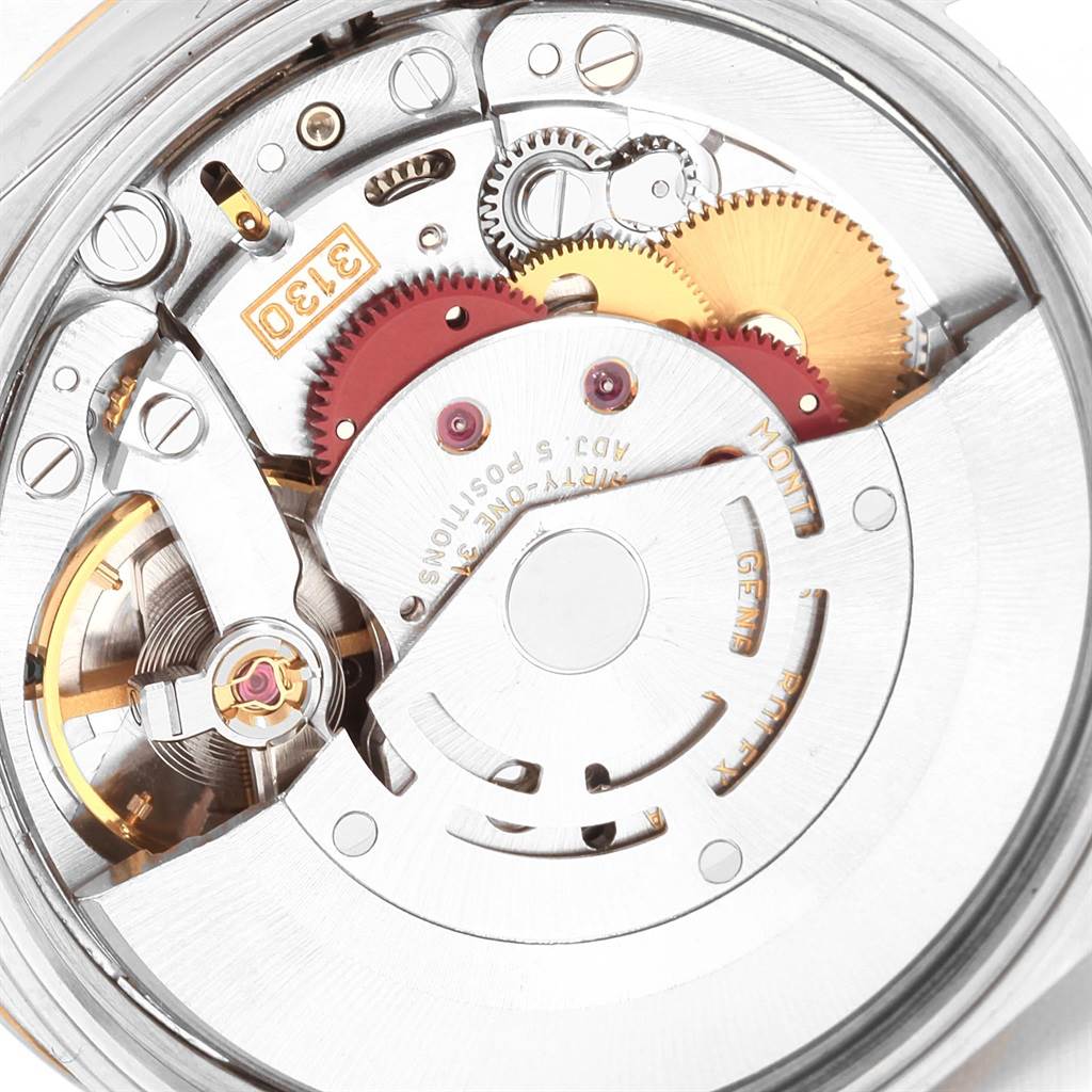 This image shows a close-up of the internal mechanism of a Rolex Oyster Perpetual 14233 Men's Steel and Gold (two tone) Blue Dial 14233 Men's Steel and Gold (two tone) Blue Dial watch, including gears and the movement.
