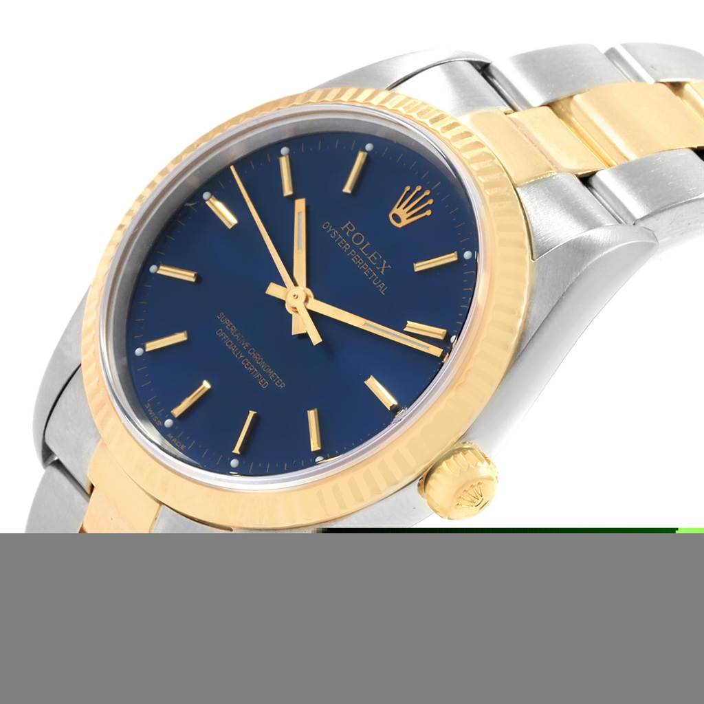 This image shows a close-up angled view of a Rolex Oyster Perpetual 14233 Men's Steel and Gold (two tone) Blue Dial 14233 Men's Steel and Gold (two tone) Blue Dial watch, highlighting its blue dial, gold bezel, and two-tone bracelet.