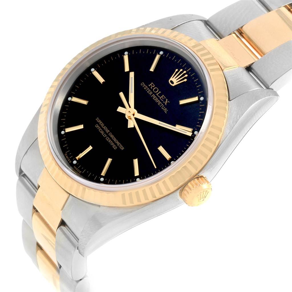 The image shows an angled view of the Rolex Oyster Perpetual 14233 Men's Steel and Gold (two tone) Black Dial 14233 Men's Steel and Gold (two tone) Black Dial watch displaying its black dial, gold bezel, and two-tone bracelet.