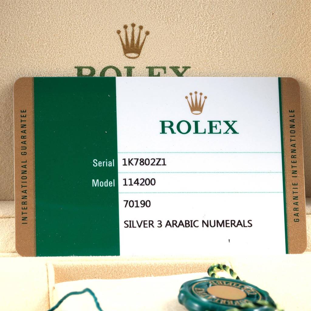 The image shows a Rolex international guarantee card and a tag for the Oyster Perpetual model 114200.
