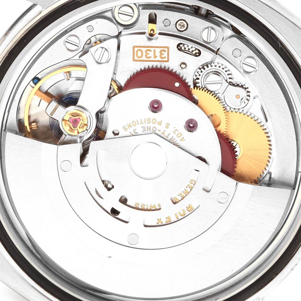 The image shows a close-up of the movement mechanism of a Rolex Oyster Perpetual 116000 Men
s Stainless Steel Blue Dial 116000 Men
s Stainless Steel Blue Dial watch, highlighting the gears and inner workings.
