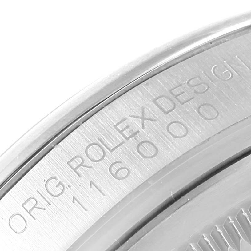 This image shows a close-up of the case back of a Rolex Oyster Perpetual 116000 Men
s Stainless Steel Blue Dial 116000 Men
s Stainless Steel Blue Dial, focusing on the engraved model number and "Rolex Design."