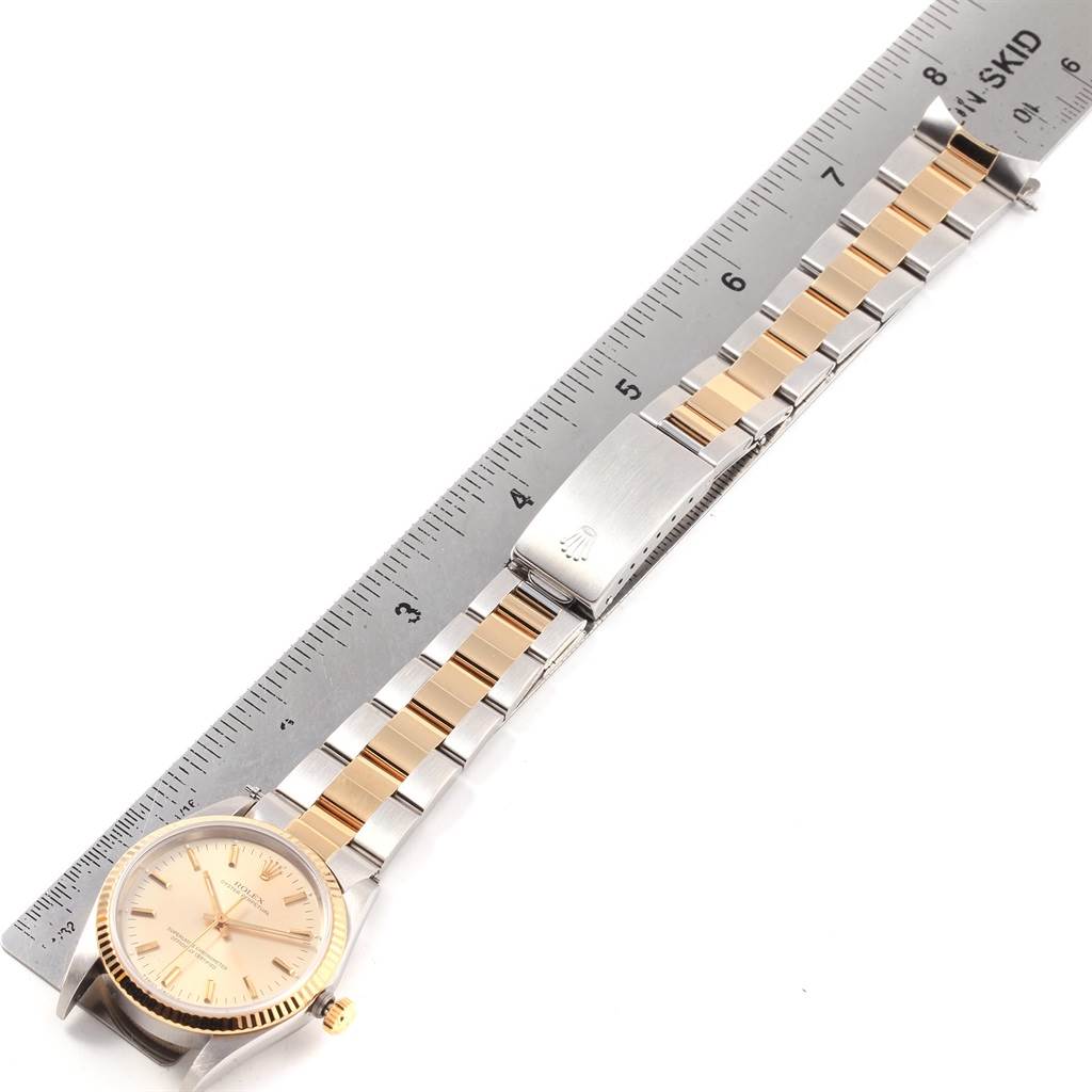 The image shows a Rolex Oyster Perpetual 14233 Men's Steel and Gold (two tone) Silver Dial 14233 Men's Steel and Gold (two tone) Silver Dial watch laid flat, highlighting its bracelet, deployment clasp, and watch face.