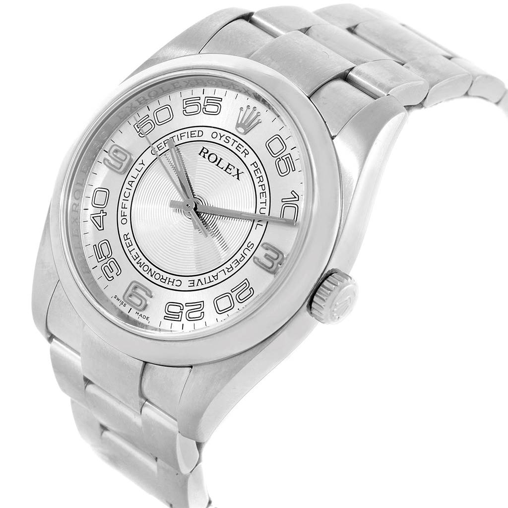 The image shows a Rolex Oyster Perpetual 116000 Men
s Stainless Steel Silver Dial 116000 Men
s Stainless Steel Silver Dial watch from an angled view, displaying its face, case, crown, and part of the bracelet.
