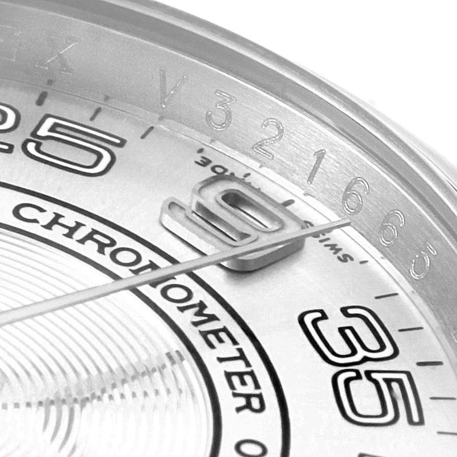 The image shows a close-up of the dial and partial bezel of the Rolex Oyster Perpetual 116000 Men
s Stainless Steel Silver Dial 116000 Men
s Stainless Steel Silver Dial watch, focusing on the numerals and text.