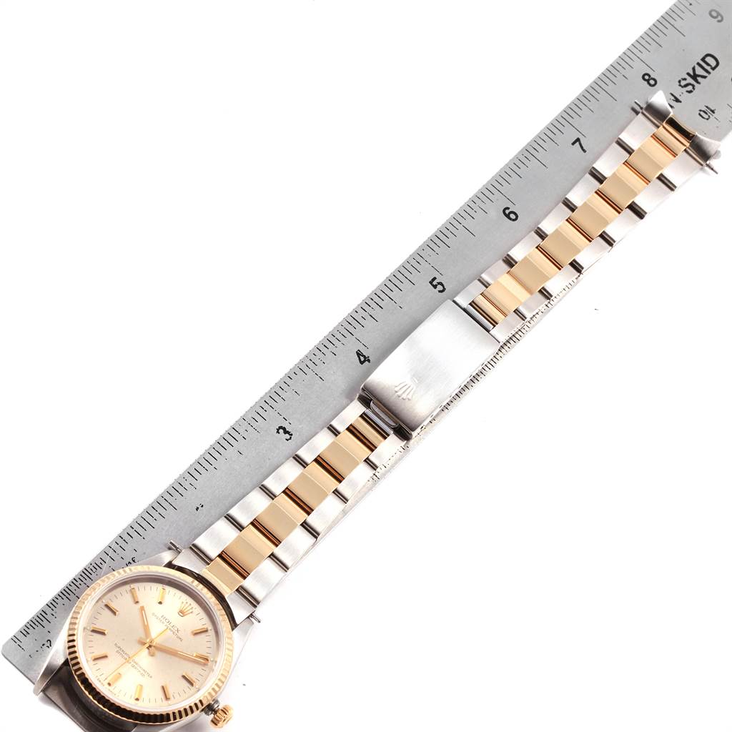 The image shows a Rolex Oyster Perpetual 14233 Men
s Steel and Gold (two tone) Silver Dial 14233 Men
s Steel and Gold (two tone) Silver Dial watch, including its face and band, measured along a ruler.
