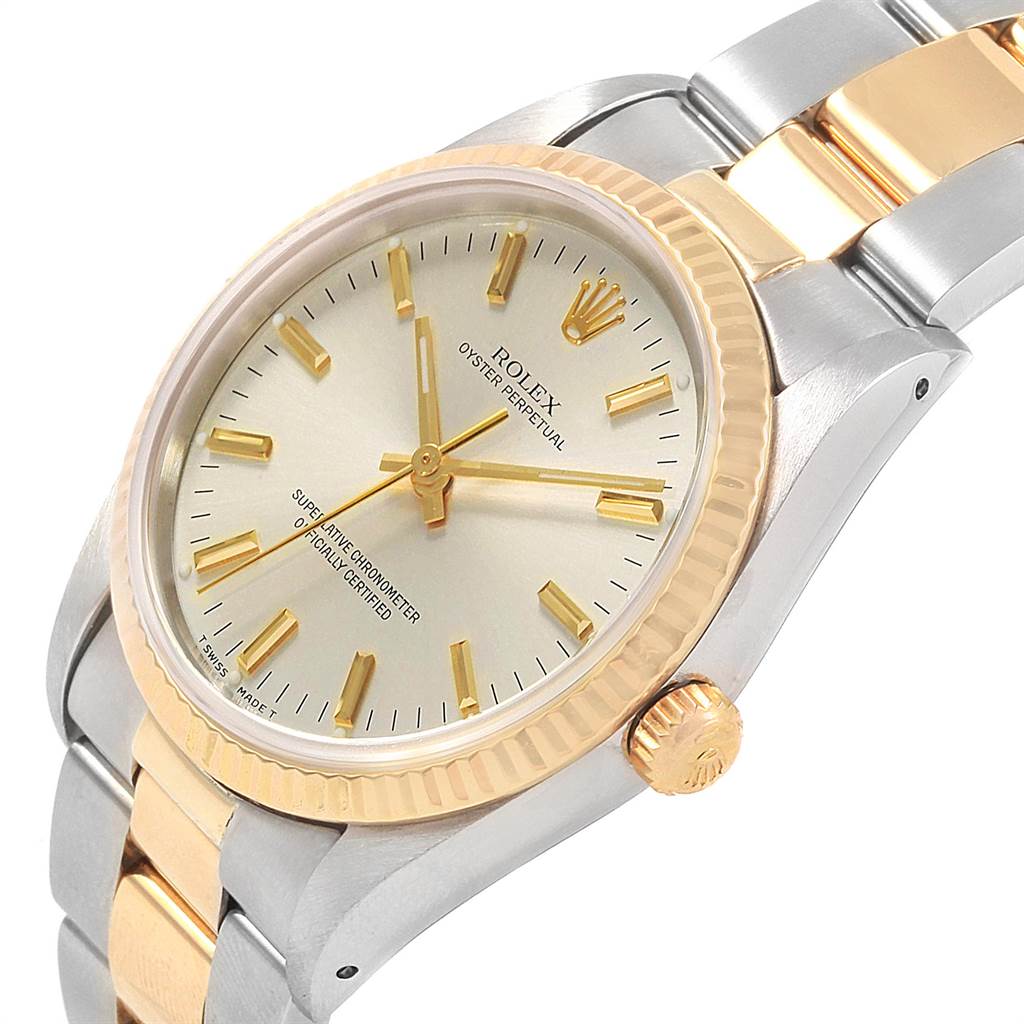 The image shows a close-up angle of a Rolex Oyster Perpetual 14233 Men
s Steel and Gold (two tone) Silver Dial 14233 Men
s Steel and Gold (two tone) Silver Dial watch, highlighting the face, bezel, crown, and part of the bracelet.