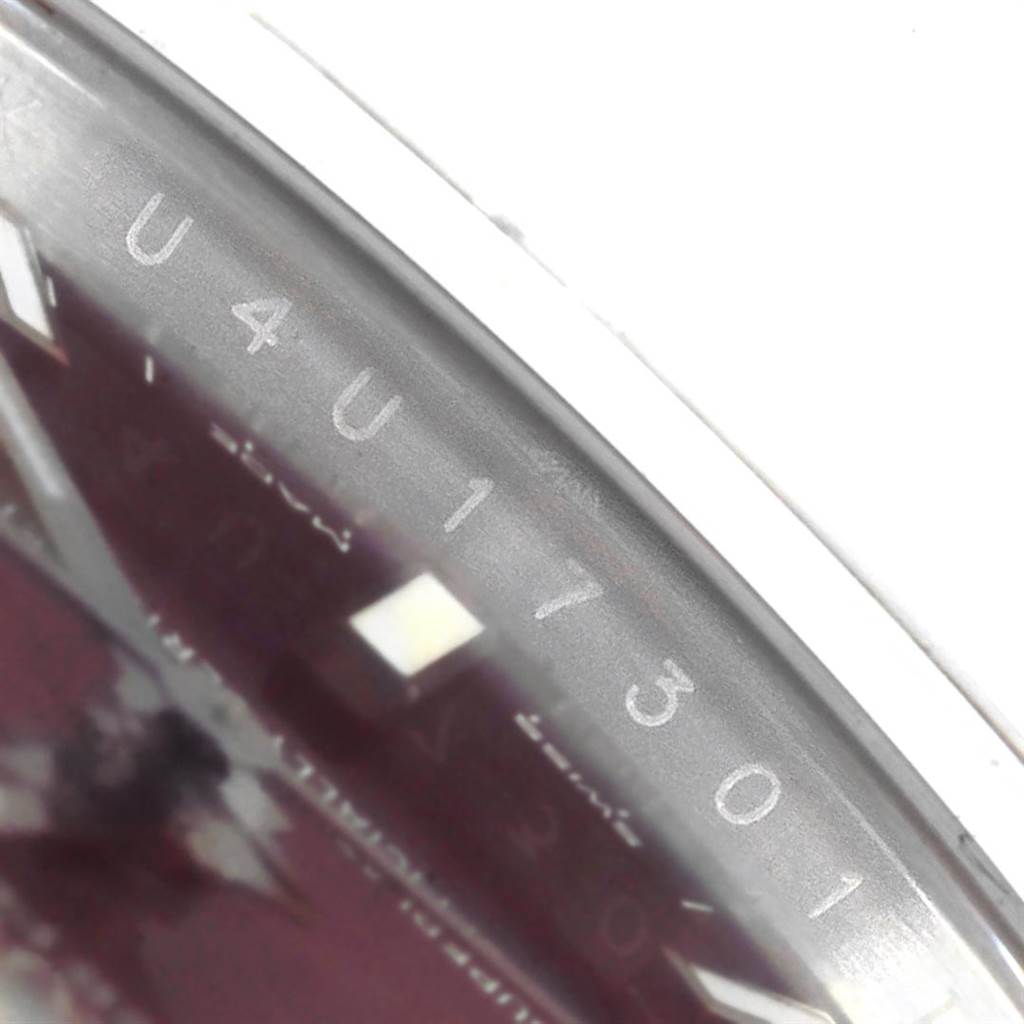 The image shows a close-up of the dial and engraved reference number on the bezel of a Rolex Oyster Perpetual 114200 Men's Stainless Steel Burgundy Dial 114200 Men's Stainless Steel Burgundy Dial watch.