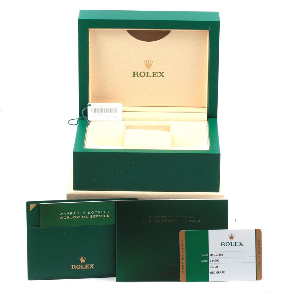 The image shows the packaging and accessories for a Rolex Oyster Perpetual 114200 Men's Stainless Steel Burgundy Dial 114200 Men's Stainless Steel Burgundy Dial watch, including the box, warranty booklet, and a card.