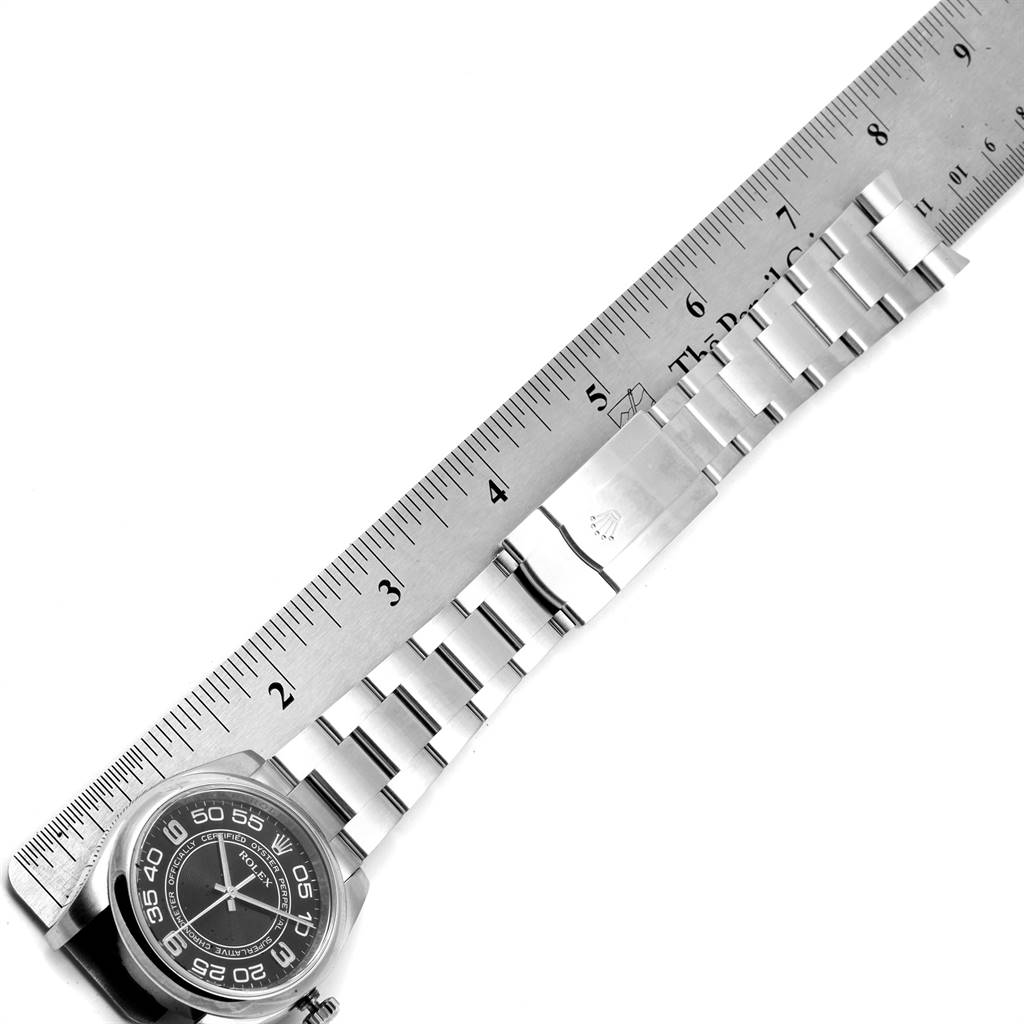 This image shows the face and bracelet of a Rolex Oyster Perpetual 116000 Men's Stainless Steel Black Dial 116000 Men's Stainless Steel Black Dial watch, alongside a ruler for scale.