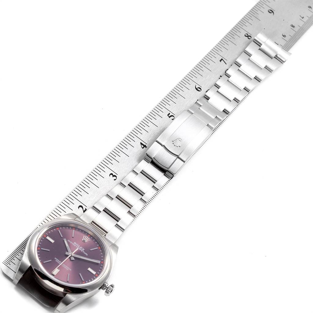 The image shows a Rolex Oyster Perpetual 114300 Men's Stainless Steel Burgundy Dial 114300 Men's Stainless Steel Burgundy Dial watch, focusing on the dial and stainless steel bracelet, with a ruler for measurement.