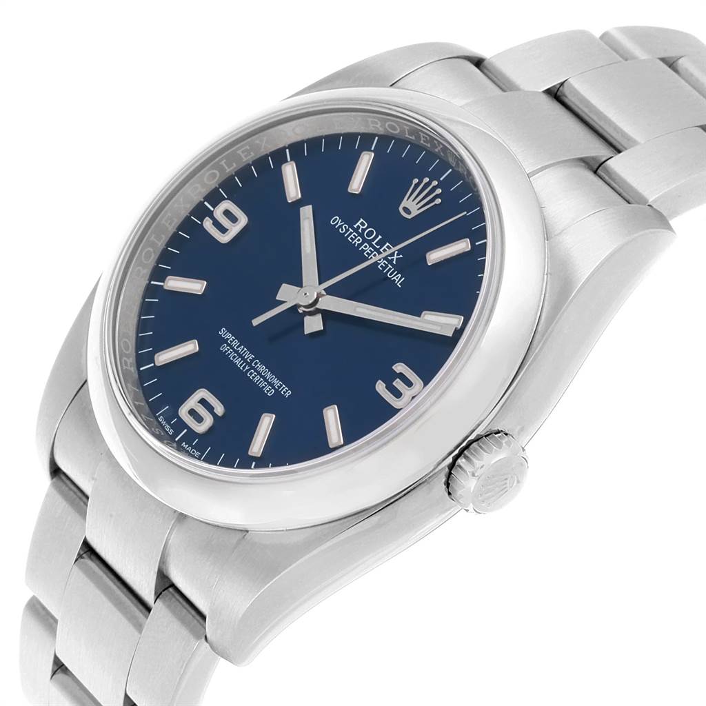 The Rolex Oyster Perpetual 116000 Men
s Stainless Steel Blue Dial 116000 Men
s Stainless Steel Blue Dial watch is shown at a slight angle, displaying the face, bezel, and part of the bracelet.