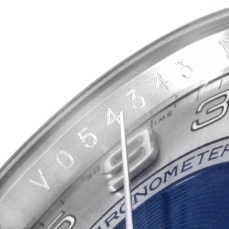 The image shows a close-up of the serial number engraving on the bezel of a Rolex Oyster Perpetual 116000 Men
s Stainless Steel Silver Dial 116000 Men
s Stainless Steel Silver Dial watch.
