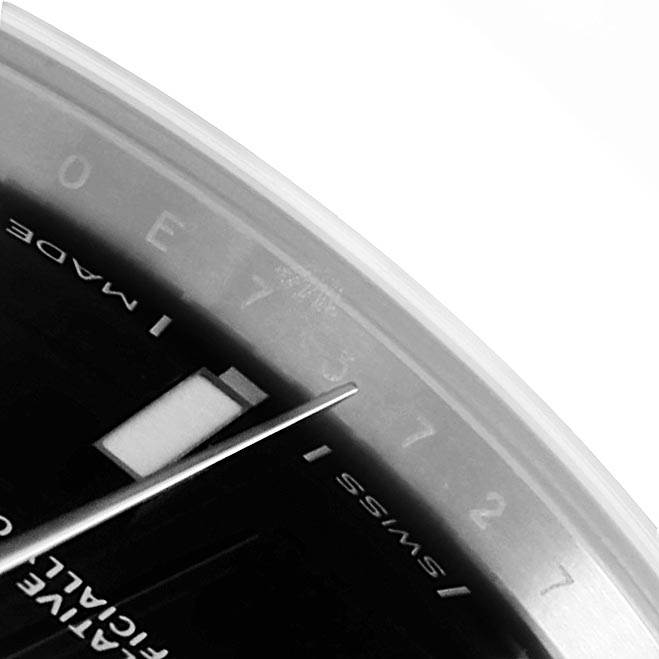 This close-up of the Rolex Oyster Perpetual 114300 Men
s Stainless Steel Black Dial 114300 Men
s Stainless Steel Black Dial watch shows the second hand, part of the dial, and the "SWISS MADE" text.