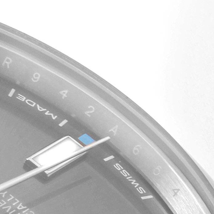 The image shows a close-up of the dial and hand of an Oyster Perpetual model by Rolex, highlighting the "Made" and "Swiss" markings.
