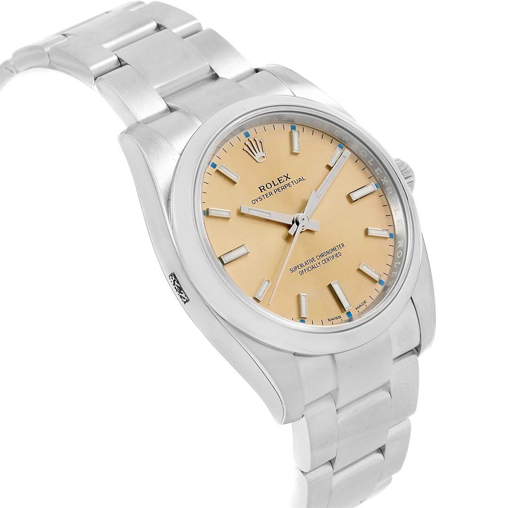 The image shows a Rolex Oyster Perpetual 114200 Men's Stainless Steel Champagne Dial 114200 Men's Stainless Steel Champagne Dial watch at an angled top view, highlighting its dial, case, and bracelet.