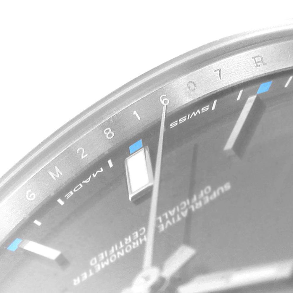 This close-up angle shows details of the dial and markers on a Rolex Oyster Perpetual 114300 Men
s Stainless Steel Grey Dial 114300 Men
s Stainless Steel Grey Dial watch.