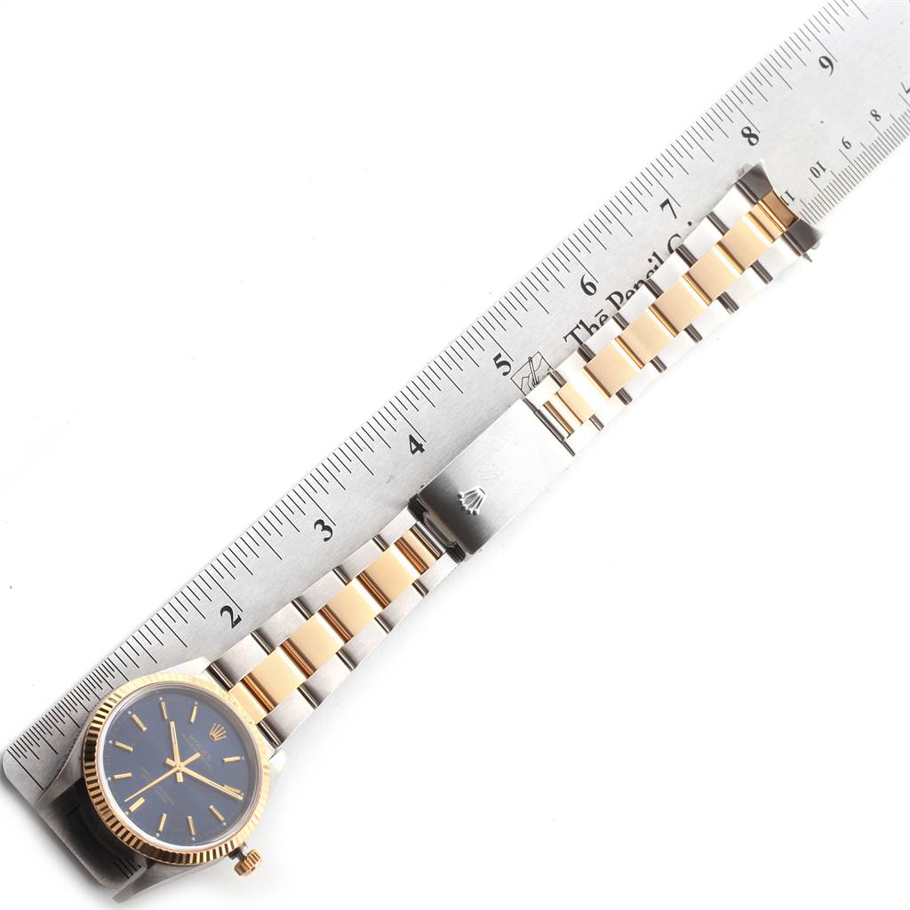 The image shows a Rolex Oyster Perpetual 14233 Men
s Steel and Gold (two tone) Blue Dial 14233 Men
s Steel and Gold (two tone) Blue Dial watch laid flat with a two-tone bracelet and a ruler for scale.