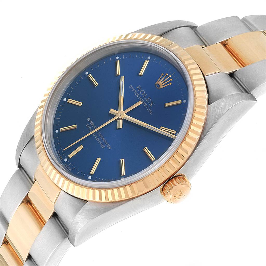 This image shows a Rolex Oyster Perpetual 14233 Men
s Steel and Gold (two tone) Blue Dial 14233 Men
s Steel and Gold (two tone) Blue Dial watch at an angled close-up, highlighting the blue dial, gold bezel, and part of the bracelet.