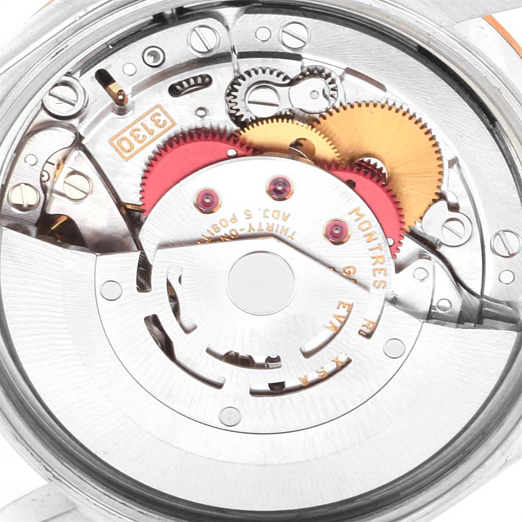 This image shows a close-up view of the internal mechanism of a Rolex Oyster Perpetual 14233 Men
s Steel and Gold (two tone) Blue Dial 14233 Men
s Steel and Gold (two tone) Blue Dial watch, focusing on its gears and components.