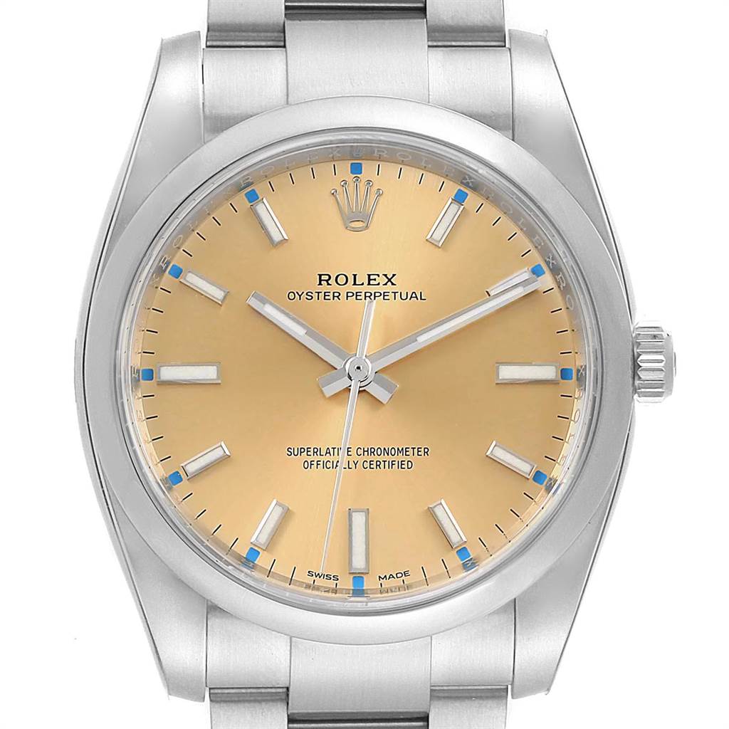 The image displays a front view of a Rolex Oyster Perpetual 114200 Men
s Stainless Steel Champagne Dial 114200 Men
s Stainless Steel Champagne Dial watch, showcasing the dial, hands, bezel, crown, and part of the bracelet.