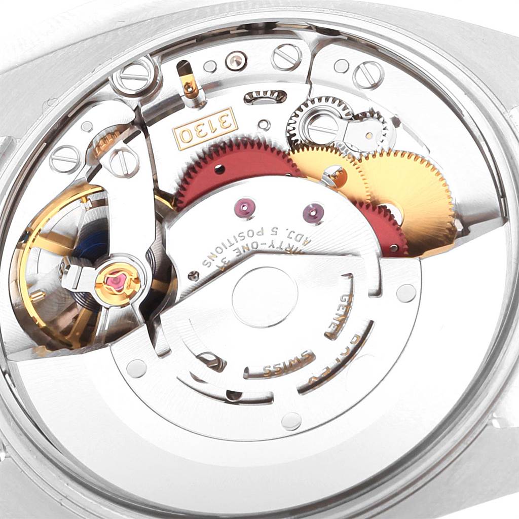 The image shows the intricate internal mechanism of a Rolex Oyster Perpetual 114200 Men
s Stainless Steel Black Dial 114200 Men
s Stainless Steel Black Dial watch, focusing on its gears and components.