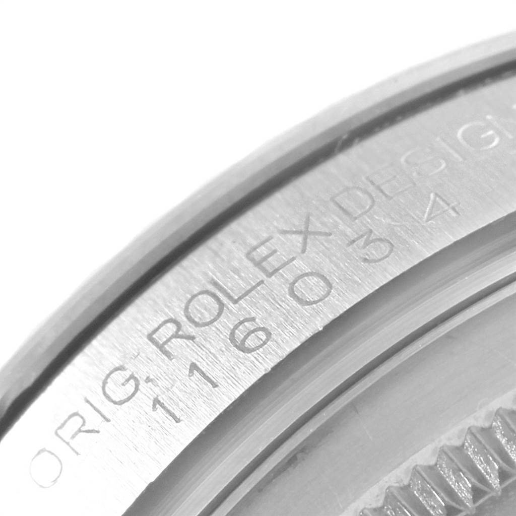 This close-up image shows the engraving on the bezel of a Rolex Oyster Perpetual 116034 Men's Stainless Steel Blue Dial 116034 Men's Stainless Steel Blue Dial watch.