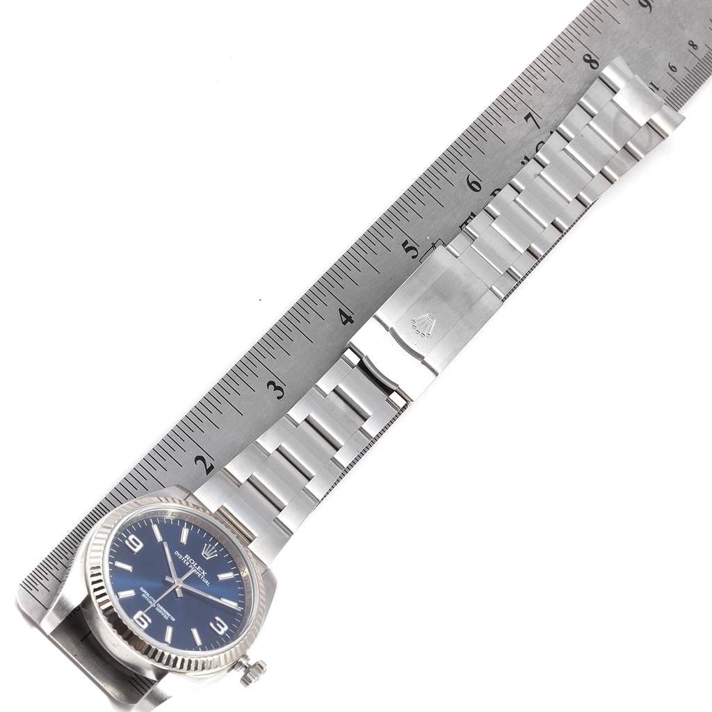 This image shows a top view of a Rolex Oyster Perpetual 116034 Men's Stainless Steel Blue Dial 116034 Men's Stainless Steel Blue Dial watch with a ruler next to it measuring its length.