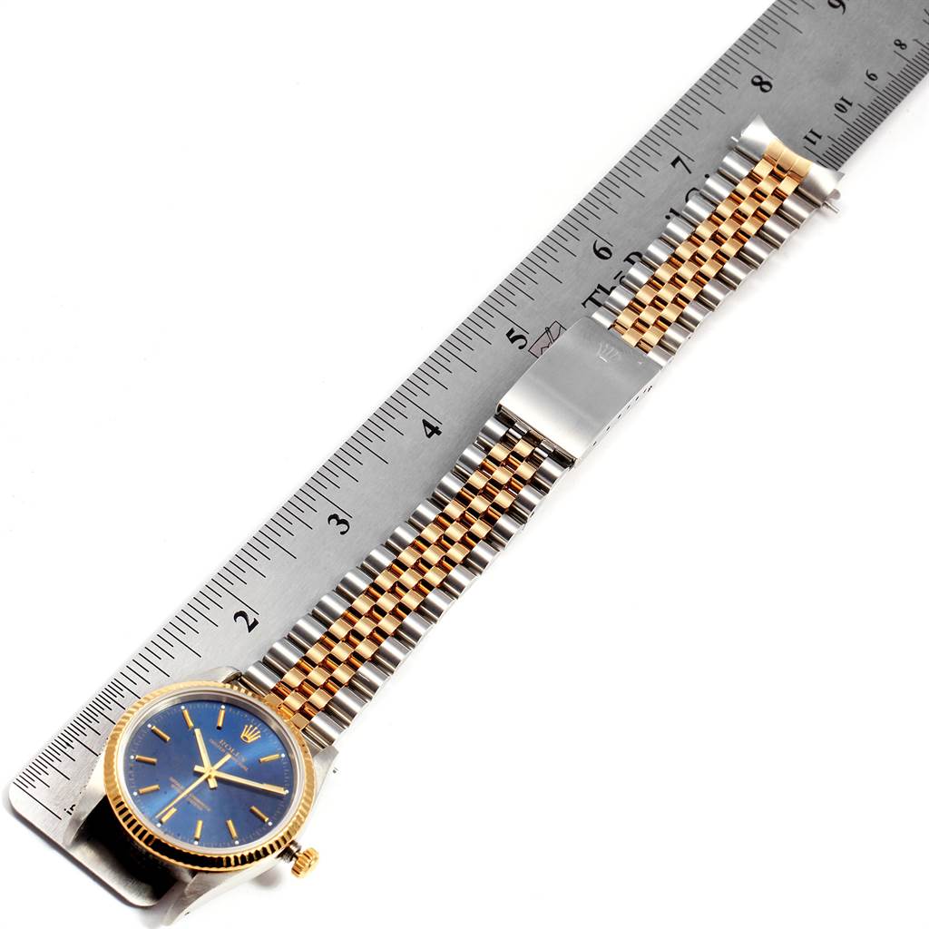 The image shows a Rolex Oyster Perpetual 14233 Men's Steel and Gold (two tone) Blue Dial 14233 Men's Steel and Gold (two tone) Blue Dial watch from a top-down angle, including the face, bezel, band, and part of the clasp.