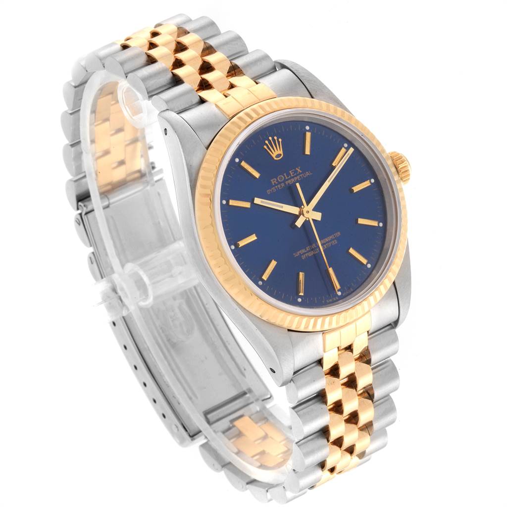 The image shows a Rolex Oyster Perpetual 14233 Men's Steel and Gold (two tone) Blue Dial 14233 Men's Steel and Gold (two tone) Blue Dial watch at a front-left angle, featuring a blue dial, gold bezel, and a two-tone metal bracelet.