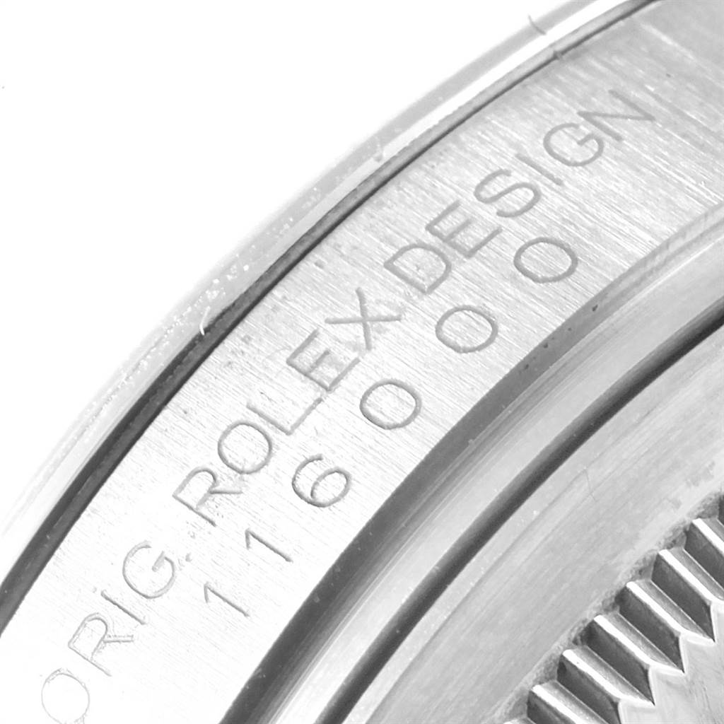 The image shows an engraved side view of the casing of a Rolex Oyster Perpetual 116000 Men's Stainless Steel Silver Dial 116000 Men's Stainless Steel Silver Dial watch with the serial number and "ORIG. ROLEX DESIGN".