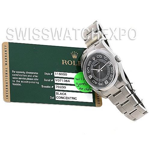 The image shows a Rolex Oyster Perpetual 116000 Men's Stainless Steel Black Dial 116000 Men's Stainless Steel Black Dial watch placed at an angle, displaying its dial, bracelet, and part of the warranty card.