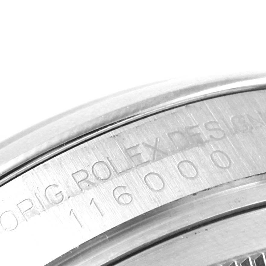 The image shows a close-up of the engraved serial number and branding on the side of a Rolex Oyster Perpetual 116000 Men's Stainless Steel Burgundy Dial 116000 Men's Stainless Steel Burgundy Dial watch.