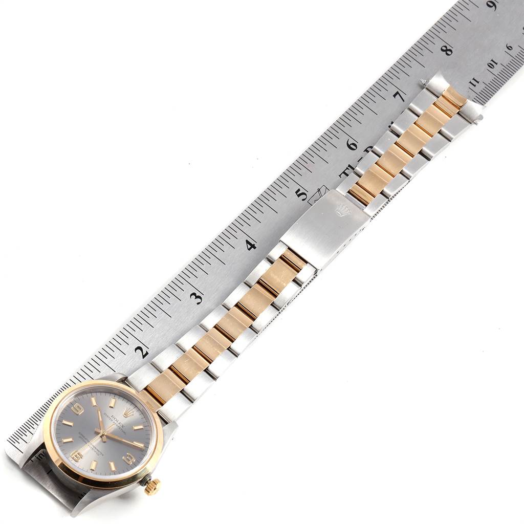 The Rolex Oyster Perpetual 14203 Men's Steel and Gold (two tone) Grey Dial 14203 Men's Steel and Gold (two tone) Grey Dial watch is shown laid flat with its band next to a ruler for scale.