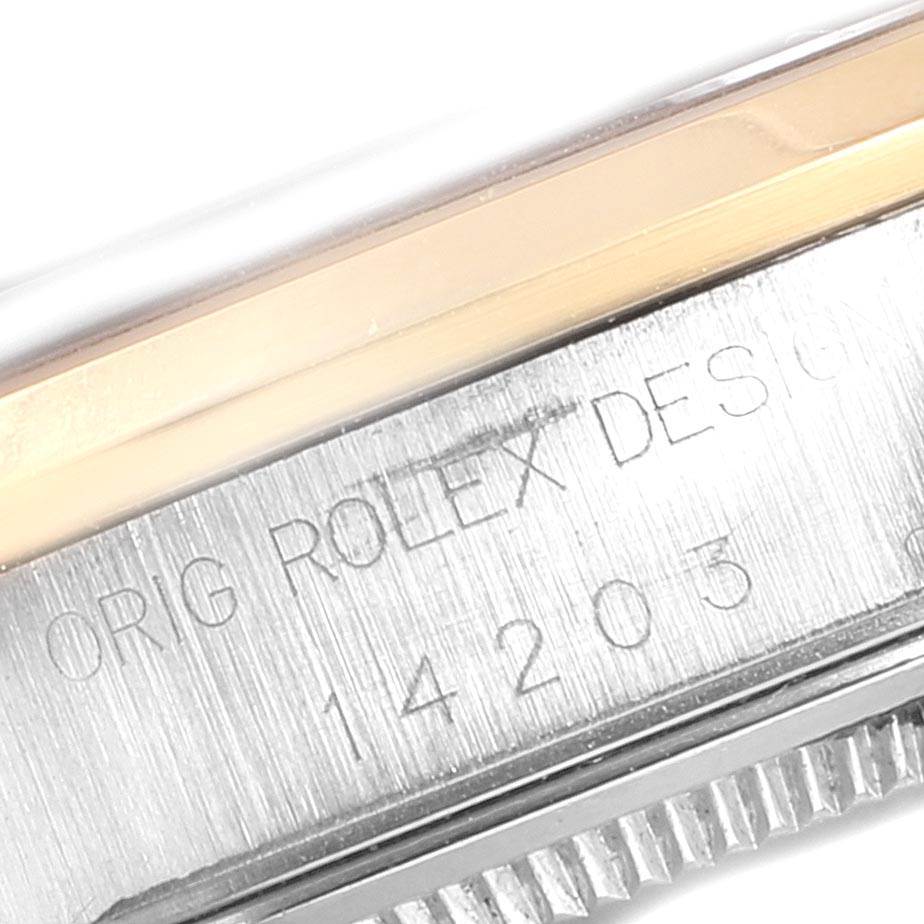 This image shows a close-up of the casing and the bezel of a Rolex Oyster Perpetual 14203 Men's Steel and Gold (two tone) Grey Dial 14203 Men's Steel and Gold (two tone) Grey Dial watch, including the model number and "Orig Rolex Design" engraving.