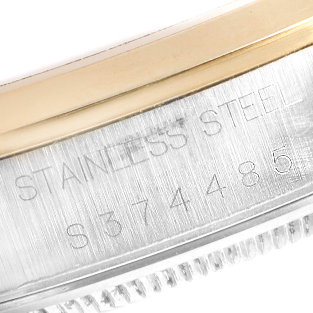 This image shows a close-up of the side of a Rolex Oyster Perpetual 14203 Men's Steel and Gold (two tone) Grey Dial 14203 Men's Steel and Gold (two tone) Grey Dial watch, displaying part of the stainless steel case and serial number.