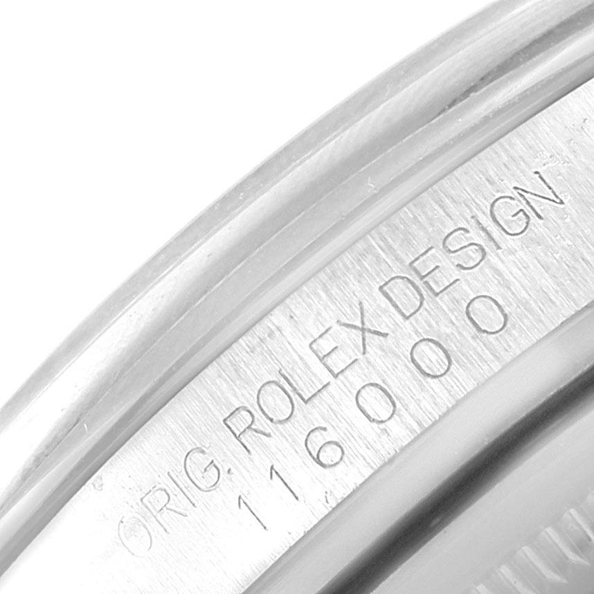 This close-up image shows the side and inner inscription of the bezel of a Rolex Oyster Perpetual 116000 Men's Stainless Steel Blue Dial 116000 Men's Stainless Steel Blue Dial watch model.