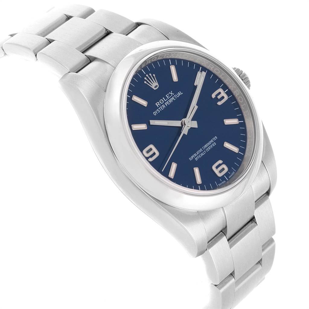 The image shows a side angle of the Rolex Oyster Perpetual 116000 Men's Stainless Steel Blue Dial 116000 Men's Stainless Steel Blue Dial watch, highlighting the bracelet, case, crown, and blue dial.