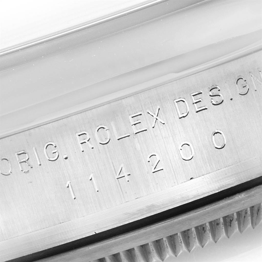 This image shows a close-up of the case side, featuring the engraved model number of the Rolex Oyster Perpetual 114200 Men's Stainless Steel Champagne Dial 114200 Men's Stainless Steel Champagne Dial watch.