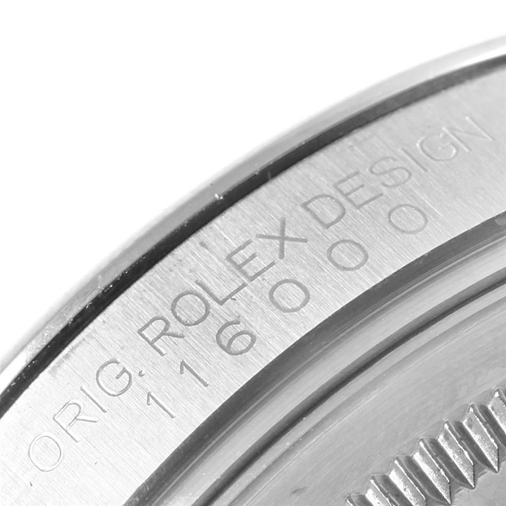 This image shows a close-up of the engraved case back of a Rolex Oyster Perpetual 116000 Men's Stainless Steel Silver Dial 116000 Men's Stainless Steel Silver Dial model watch.