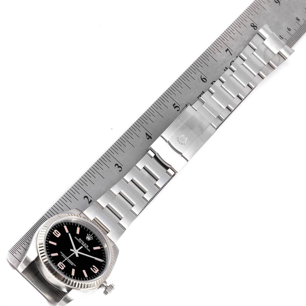 The image shows a Rolex Oyster Perpetual 116034 Men's Stainless Steel Black Dial 116034 Men's Stainless Steel Black Dial watch laid flat with its bracelet extended alongside a ruler.