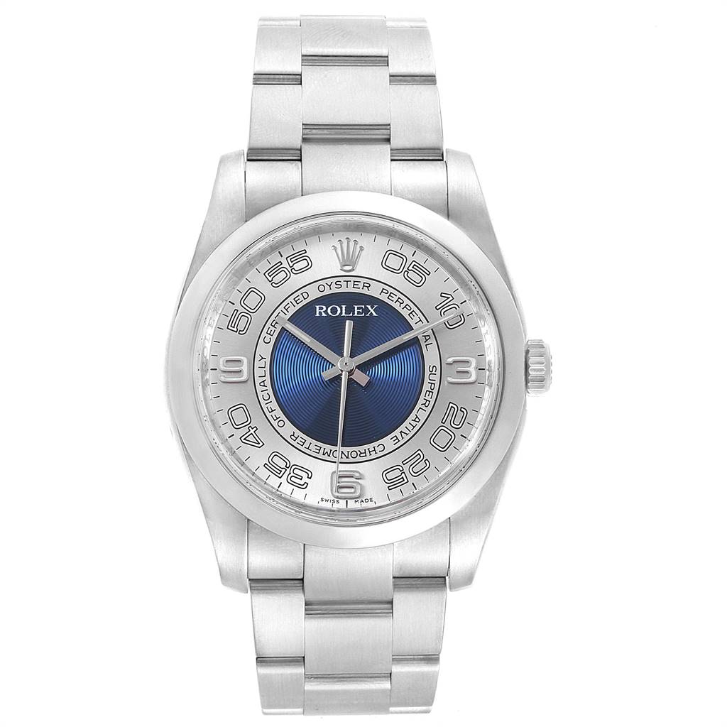 The image shows a front view of a Rolex Oyster Perpetual 116000 Men's Stainless Steel Silver Dial 116000 Men's Stainless Steel Silver Dial watch, featuring a metallic bracelet and a blue and silver dial.