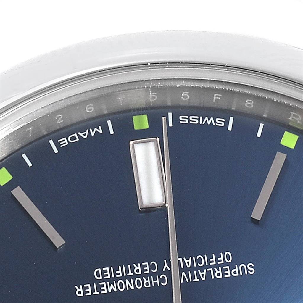 The image shows a close-up angle of the dial of a Rolex Oyster Perpetual 114300 Men's Stainless Steel Blue Dial 114300 Men's Stainless Steel Blue Dial watch, focusing on the hour markers, hands, and text "SWISS MADE."
