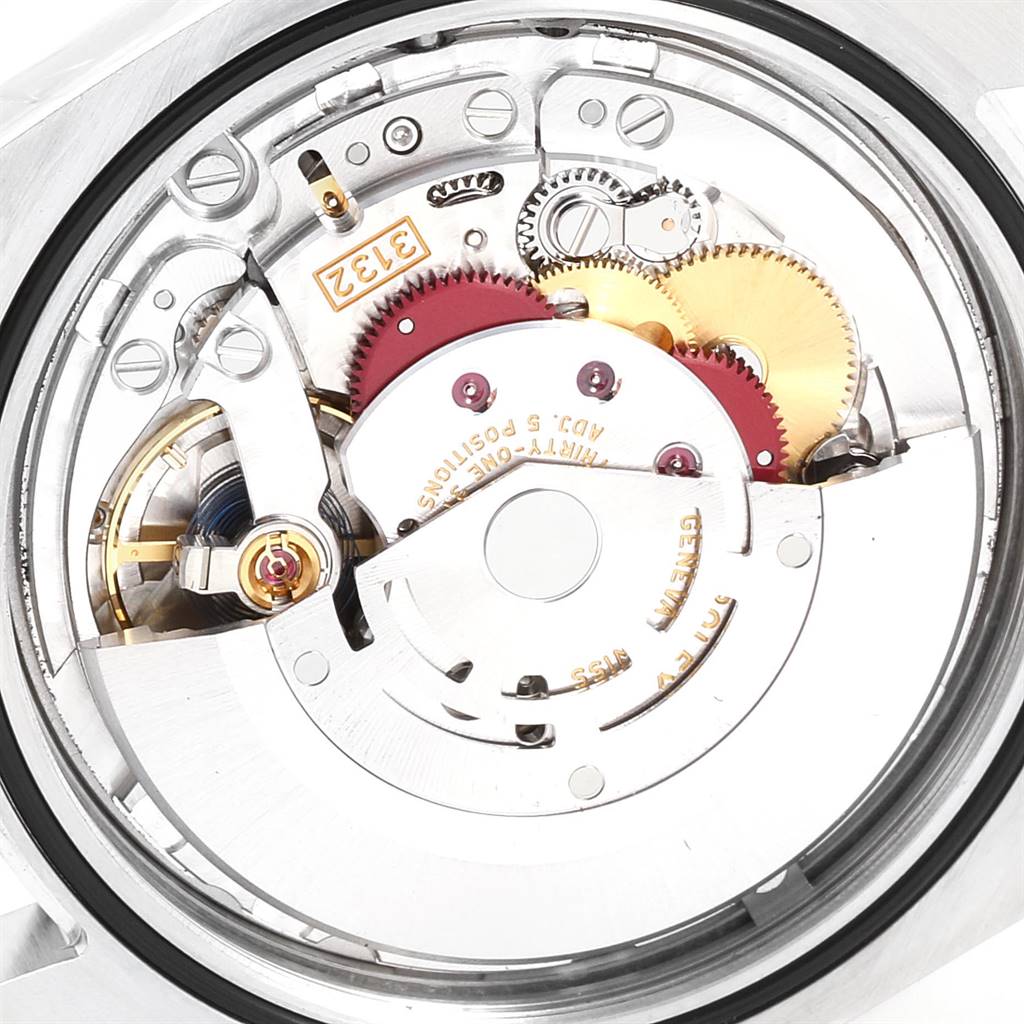 The image shows a close-up of the movement mechanism of a Rolex Oyster Perpetual 114300 Men's Stainless Steel Blue Dial 114300 Men's Stainless Steel Blue Dial watch from the rear angle.