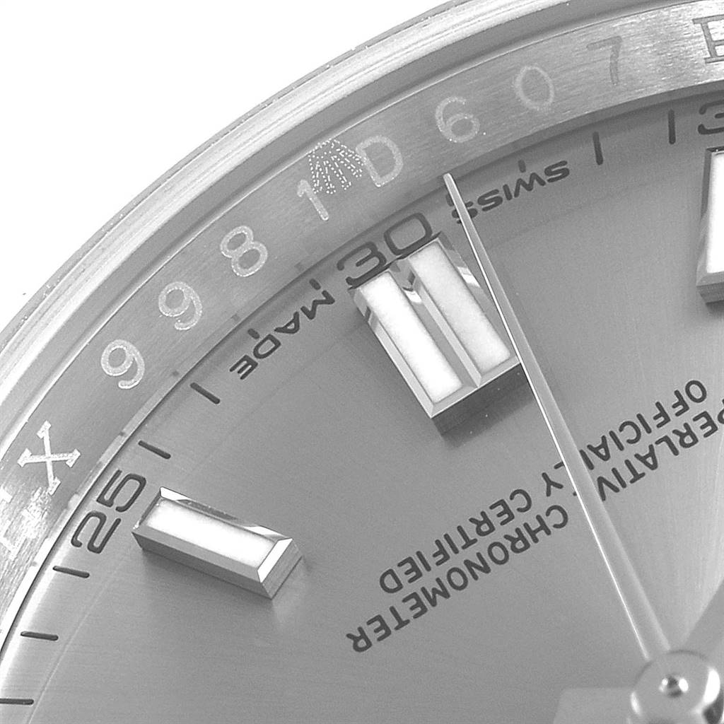The image shows a close-up of the dial and bezel of a Rolex Oyster Perpetual 116000 Men's Stainless Steel Grey Dial 116000 Men's Stainless Steel Grey Dial watch, featuring hour markers and part of the branding.