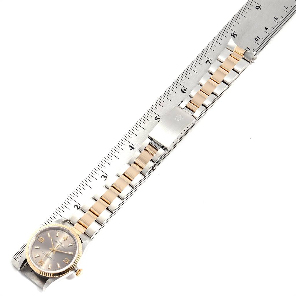 The image shows an overhead view of a Rolex Oyster Perpetual 14233 Men's Steel and Gold (two tone) Grey Dial 14233 Men's Steel and Gold (two tone) Grey Dial watch and part of its band, placed against a measuring ruler.