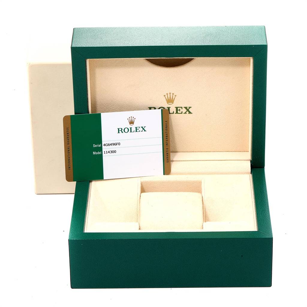 This image shows the packaging and guarantee card of a Rolex Oyster Perpetual 114300 Men's Stainless Steel Silver Dial 114300 Men's Stainless Steel Silver Dial model.